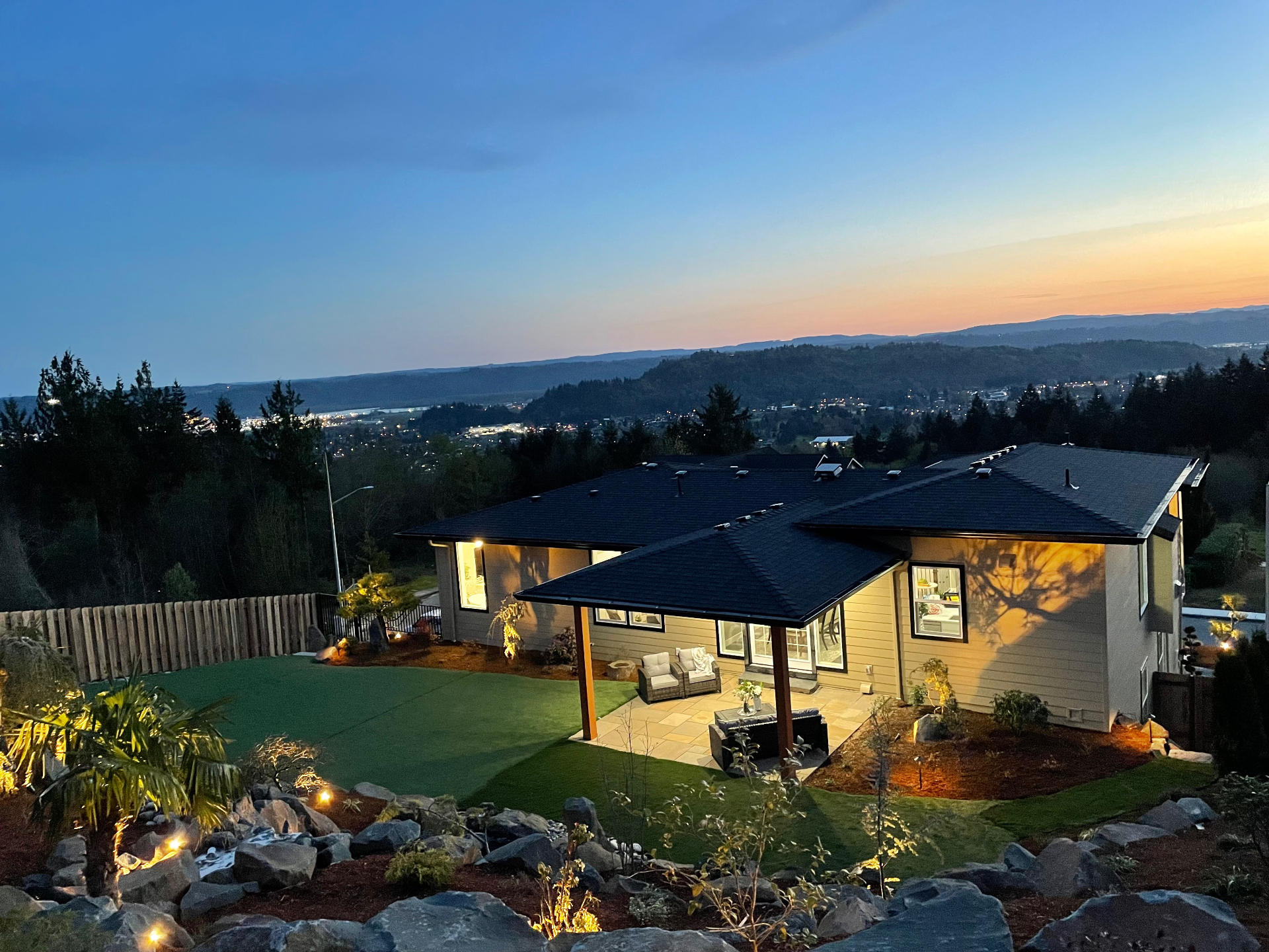 Hilltop home at dusk with landscape lighting and valley views